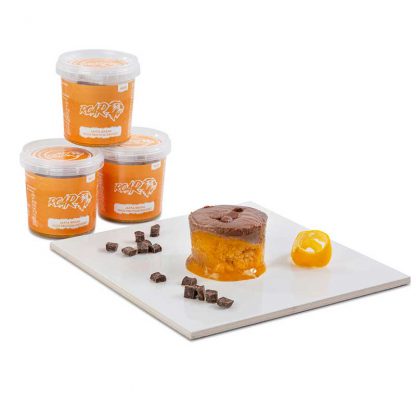 Three pots of ROAR high protein jaffa break desserts stacked behind a board with one of the same emptied onto it along with some chocolate chips