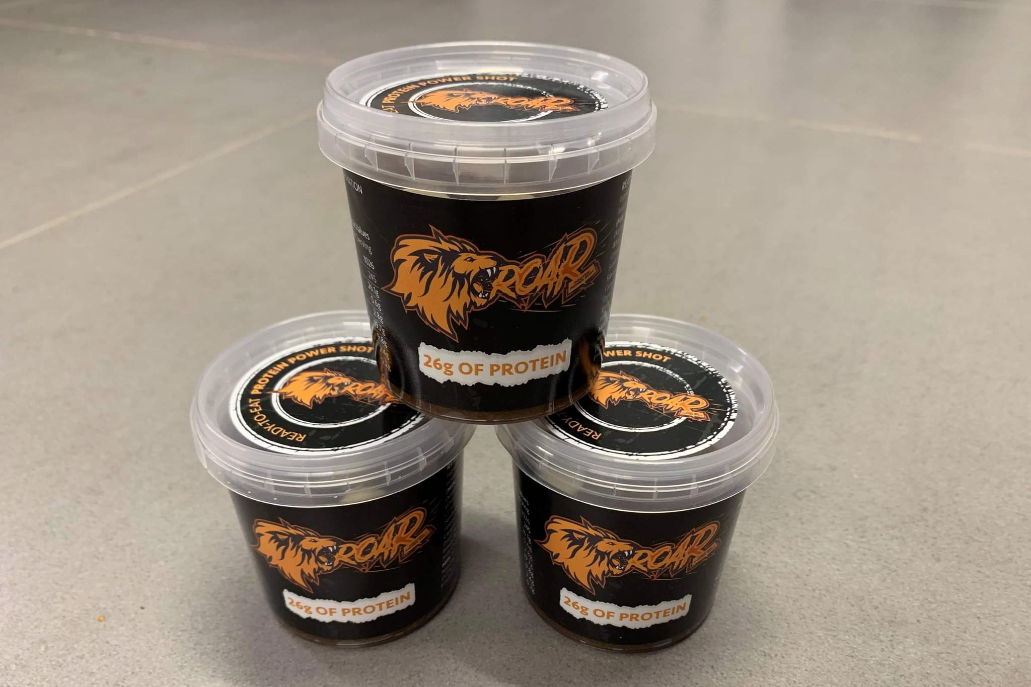 Protein power shot pots three on top of each other with ROAR branding
